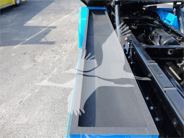 Peterbilt 337 tow truck chassis visible with blue paint and a textured step, engine bay area in background.