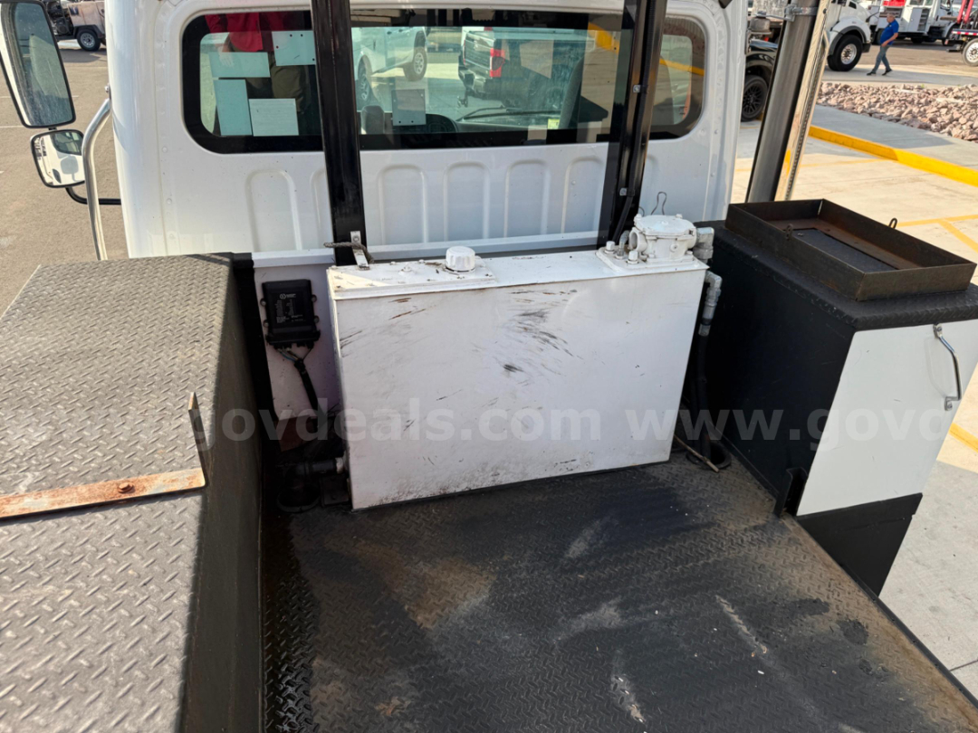 Flatbed area of a 2020 Freightliner TEREX TC-55 bucket truck showing a large white rectangular storage box and a black tool cabinet on a diamond plate platform.