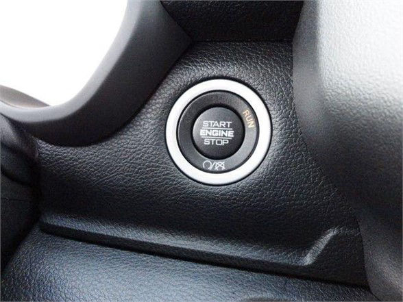 Car interior showing a circular push-to-start button labeled 'START ENGINE STOP' with 'RUN' and 'OFF' indicators around it.