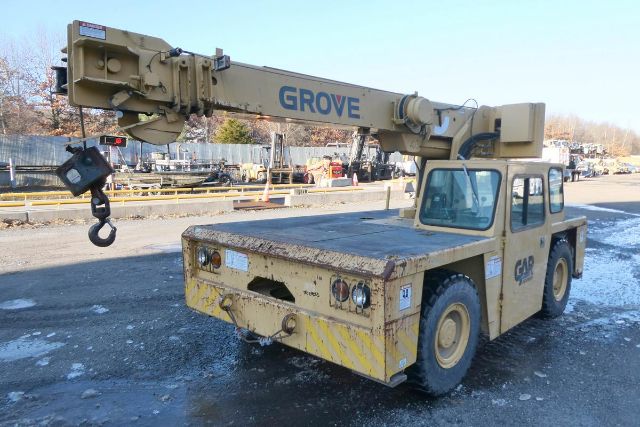 Grove YB4410 rough-terrain crane mounted on a beige truck chassis with extended boom and hook, front yellow bumper, in an outdoor lot.