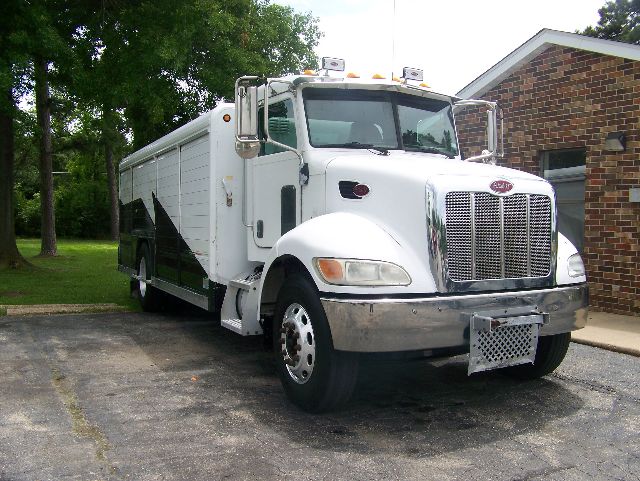 Peterbilt 335 box truck shown front-left angle with white cab and chrome grille, side cargo box, daytime outdoor setting.