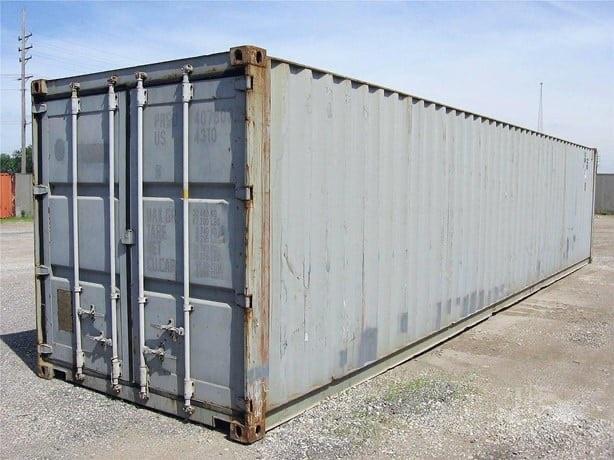 40-foot used shipping container with closed doors and weathered gray metal walls in an outdoor lot.