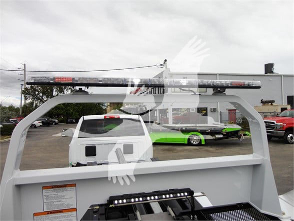 Ram 5500 HD SLT truck bed view with emergency light bar mounted on top and a green car in the background.