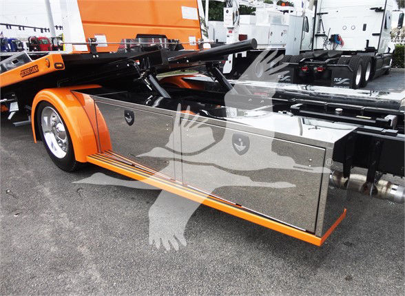 Peterbilt 337 tow truck chassis side with large polished tool/storage compartments and orange accents.