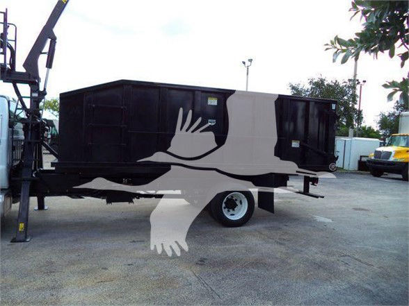 Black dump bed/grapple trailer on dual-axle chassis with Ford F-650/SD styling; no legible labels visible.