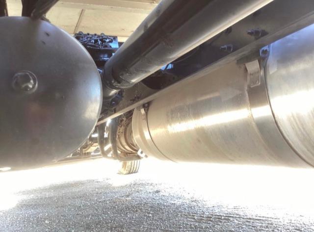 Peterbilt 579 undercarriage showing exhaust pipe and cylindrical fuel tank View under truck