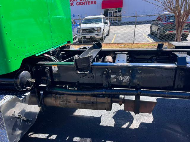 Peterbilt 348 truck chassis with green cab viewed from side; visible frame rails, fuel tank, and suspension components.