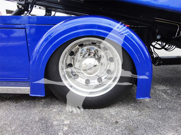 Front wheel area of a blue Peterbilt 337 truck showing chrome wheel and fender.