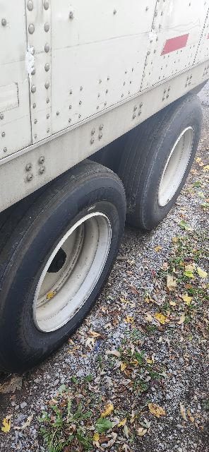 Rear wheels of a 2014 Wabash dry van trailer showing dual tires and riveted aluminum side panel.