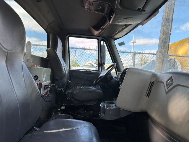 Interior of a 2009 International 7500 vacuum truck cab showing driver's seat, passenger seat, steering wheel, dashboard, and equipment panel.