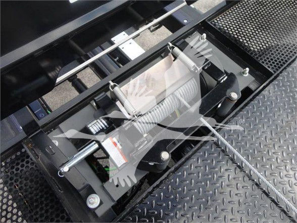 Tow truck winch assembly with steel cable reels and mounting brackets on diamond plate platform.