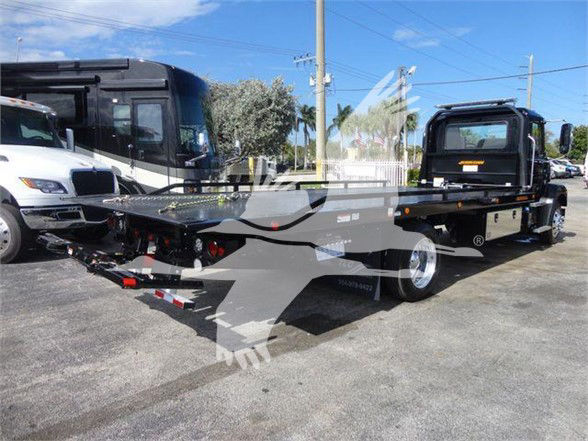 2025 Mack MD6 tow truck flatbed rear view showing car hauler bed and dual rear tires.