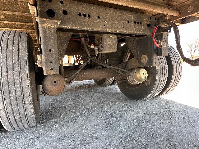 Underneath view of a 2015 Wabash DuraPlate Dry Van trailer showing axles, suspension, leaf springs, twin rear wheels, and air hoses.