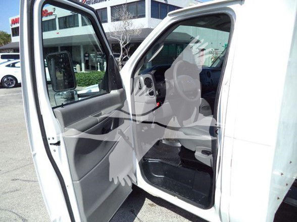 Ford E-450 dump truck cab interior with open driver door showing steering wheel and seats.