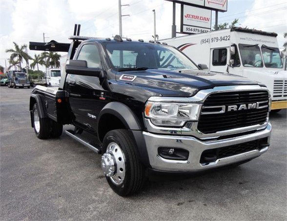 2024 Ram 4500 HD SLT tow truck with black cab, chrome grille, dual rear wheel, side steps, and RAM emblem on grille.