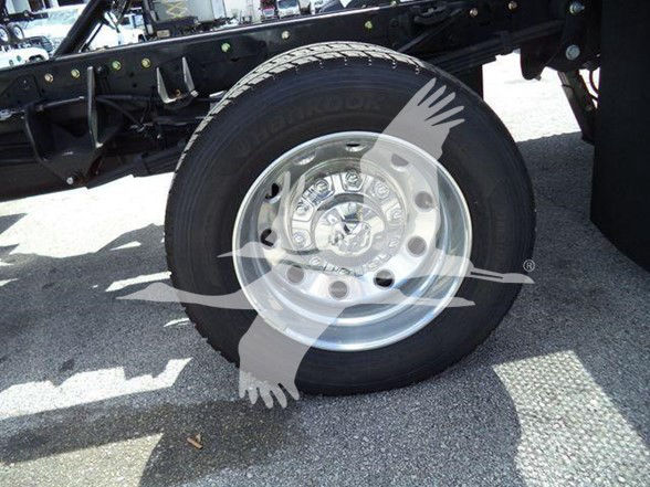 Wheel and tire on a Ram 5500 chassis with chrome hub, part of a tow truck chassis; overlaid watermark obscures some details.