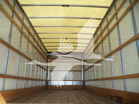 Truck trailer cargo area showing empty wooden floor and side walls; overlay watermark silhouette of a handbird logo across the image.