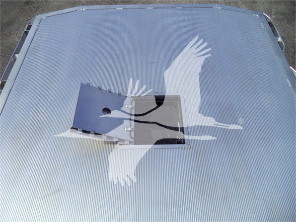 Ram 5500 cab roof showing a rectangular hatch/enclosure on a corrugated metal bed with a raised lid and hinge.