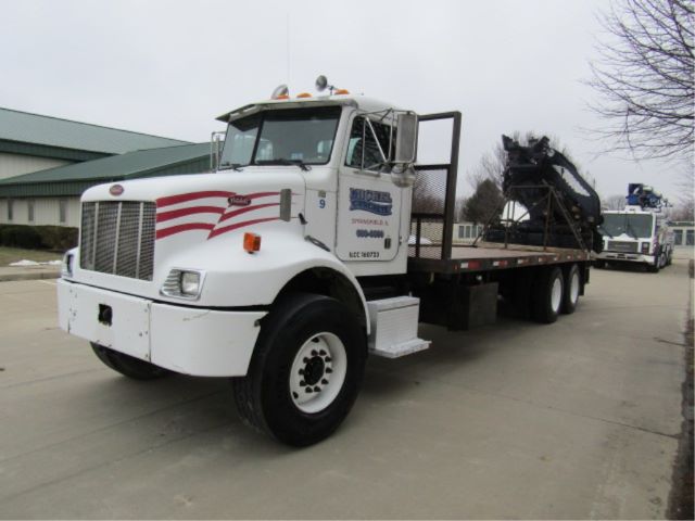 Peterbilt 330 heavy tow truck flatbed with crane boom in service bay area