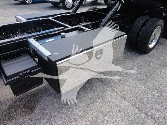 Isuzu NRR truck chassis with a large rectangular toolbox/storage box mounted near rear wheel, showing metal frame and hitch area.