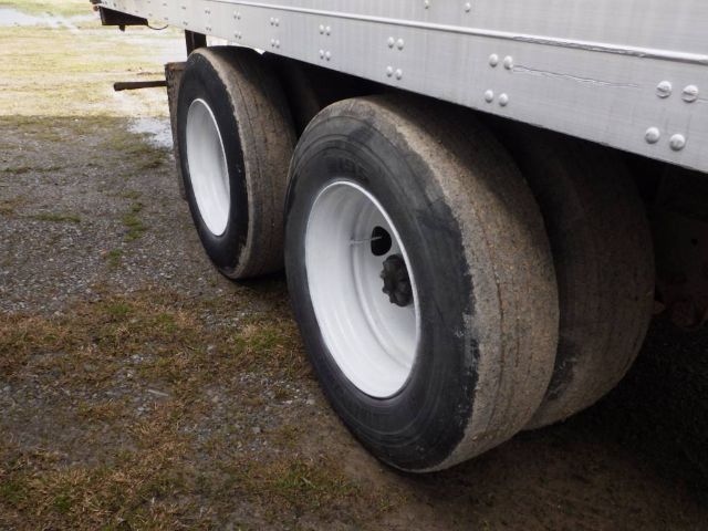 Trailer tires and lower side of a Fruehauf storage/short haul trailer showing dual wheels and aluminium side panel.