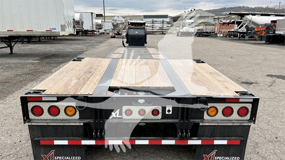 Back view of a 2024 XL Specialized Mini Deck trailer with wooden deck, dual rear lights, and branding. VIN 4U3J05324RL023099, stock 53-6198.