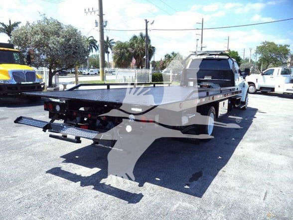 Tow truck flatbed on a 2015 Ford F650 XLT with rear ramps extended.