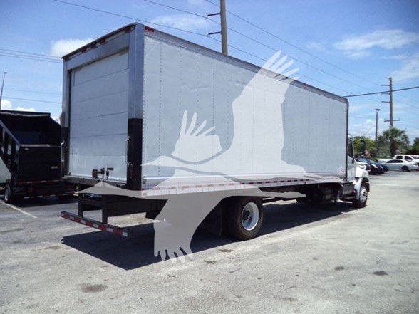 Truck trailer in a lot showing a silver box body and white cab, reefer truck.