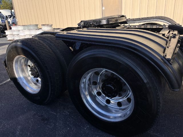 Wheelset on the rear of a Mack CHU613 Pinnacle tractor-trailer chassis showing dual rear axles with polished steel wheels and black tires.