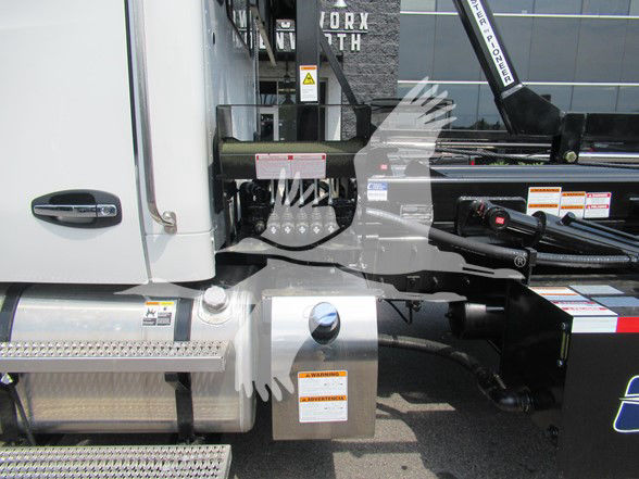 Kenworth T480 truck side view showing cab, fuel tank, and hydraulic components with warning labels.