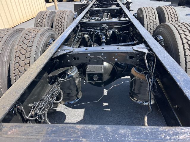Freightliner M2 chassis frame and rear axle area showing dual rear axles with suspension and wiring, viewed from rear of cabless frame.