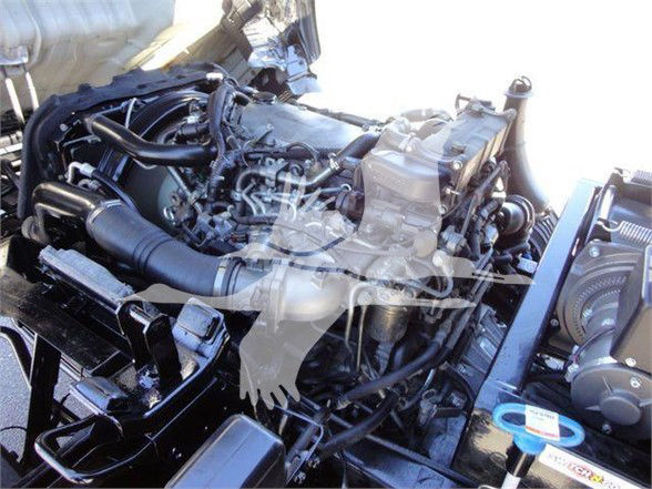 Isuzu NRR engine bay showing multiple hoses and components; view focuses on diesel engine and surrounding mechanicals.