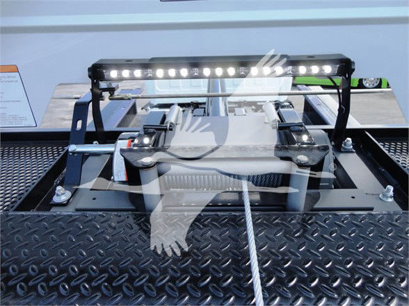 Truck hitch area with a mounted LED light bar on a platform, hydraulic components, and metallic diamond plate surface visible.