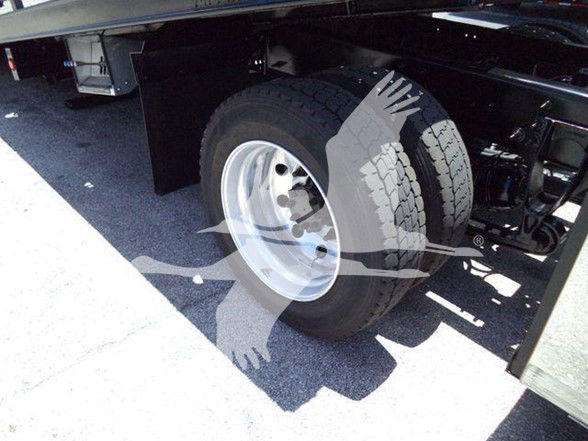 Wheel and tire under the rear of a truck chassis, with the inner structure visible; no legible text on components.