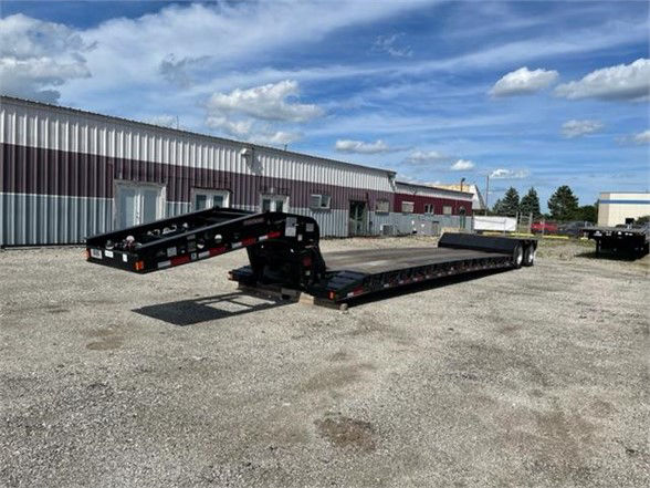 Fontaine Renegade N20 double drop deck trailer showing low-profile frame and ramps, black with safety rails and reflective tape.