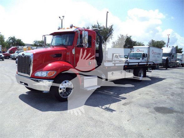 Red 2021 Peterbilt 337 tow truck with flatbed in a dealership lot; visible text includes permutation of stock and model but no legible small labels.