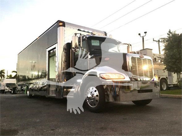 Peterbilt 337 truck in service bay with attached trailer, chrome front grille and headlamps