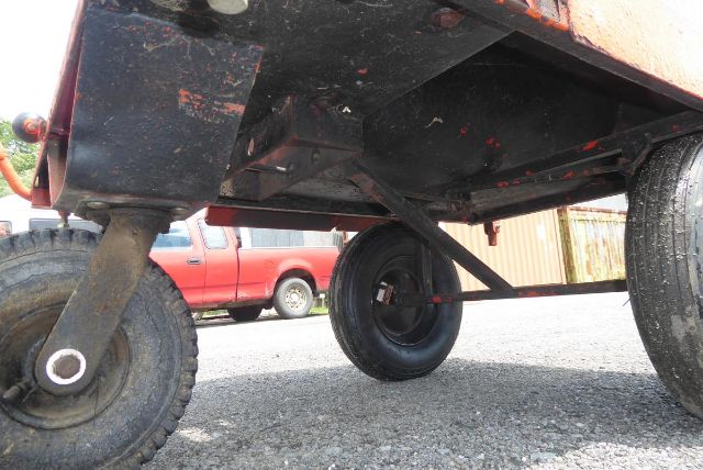 Rear view of agricultural equipment trailer with wheels and undercarriage; visible tire, frame, and hitch; no legible labels or stickers.