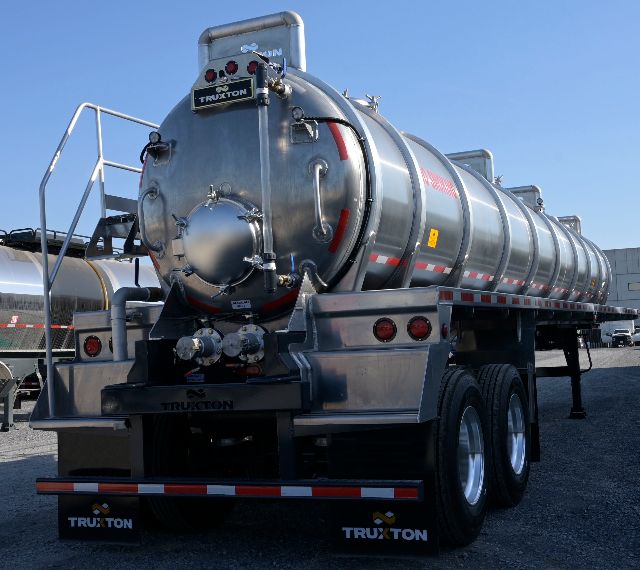 Truxton aluminum 150BBL vacuum trailer rear view showing cylindrical tank with rear hatch, dual axles, mud flaps labeled TRUXTON, and ladder/rails.