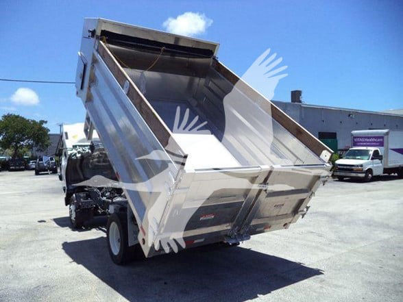 Isuzu dump truck in a tilted dumping position showing the bed and hydraulic system. Visible text on the side panels may include model and branding but not clearly legible.