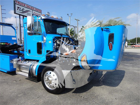 Blue 2022 Peterbilt 337 tow truck with hood open, showing engine bay and front wheel, stock number J56606.