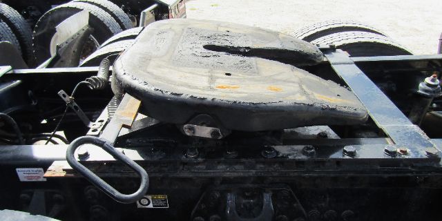 Truck cab and chassis area with a spare fuel tank and handle visible on a Kenworth T680 chassis.