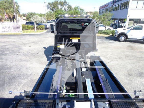 Tow truck bed and hydraulic lift components with a visible label 'Jerr-Dan' on the cab area. Other faint elements include metal rails and control levers along the bed.