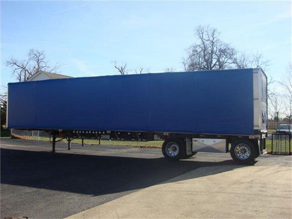 2024 Fontaine AERO CONESTOGA tarp system trailer with blue curtain sides in stock photo.