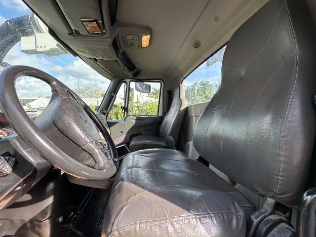 Interior of a 2014 International 7500 vacuum truck showing driver seat, steering wheel, and front passenger seat.