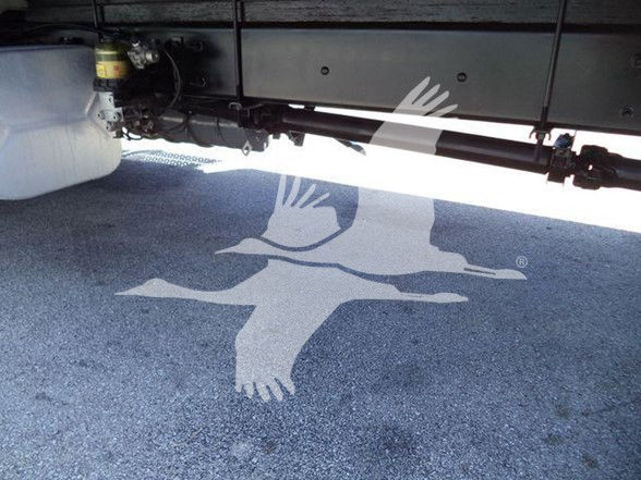 Underneath view of a 2019 International DURASTAR 4300 chassis with underbody components and a nearby white reservoir.