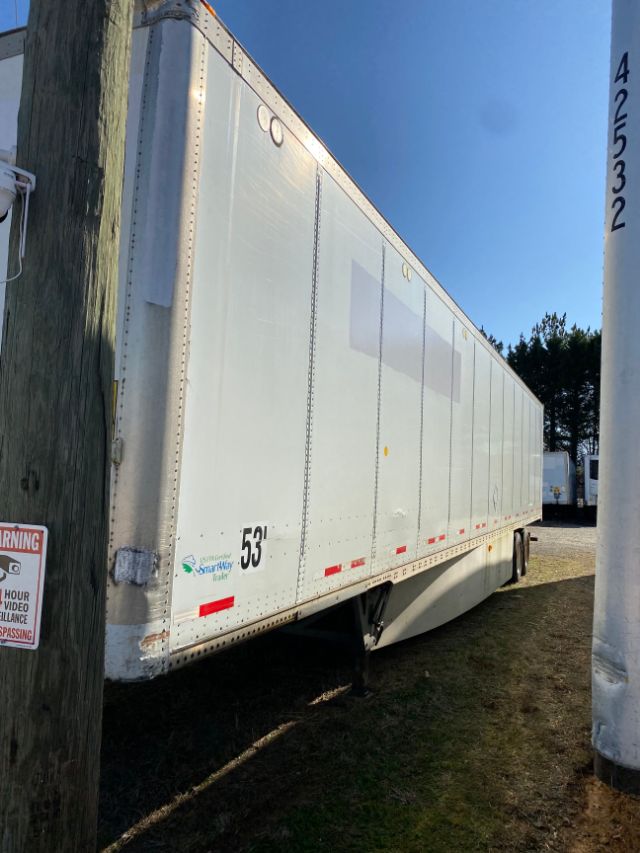 Long white Wabash trailer with Duraplate sides showing 53' length and SmartWay logo, parked near utility pole.