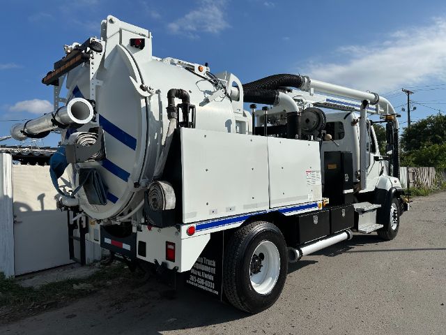 Vacuum truck in service-style setup with large rear vacuum tank, hoses, and chrome details on a Freightliner 108SD chassis.