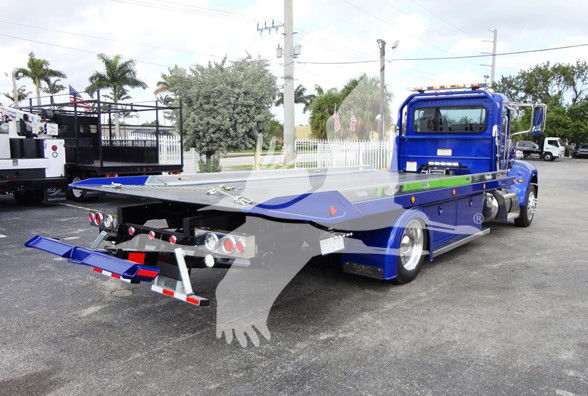 Blue 2022 Peterbilt 337 tow truck with flatbed removed at rear, showing platform and rear dual lights, chrome bumper, and blue cab.