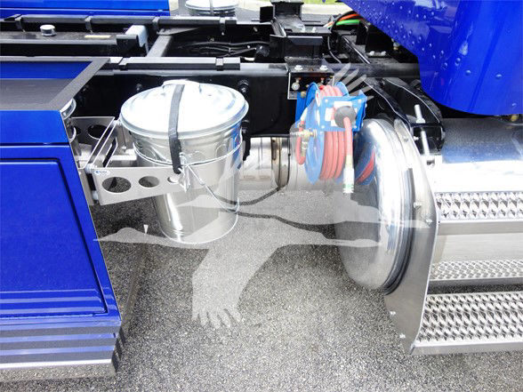Truck fuel tank and air reservoir mounted under a Peterbilt 337 cab with chrome steps and blue body paneling visible.